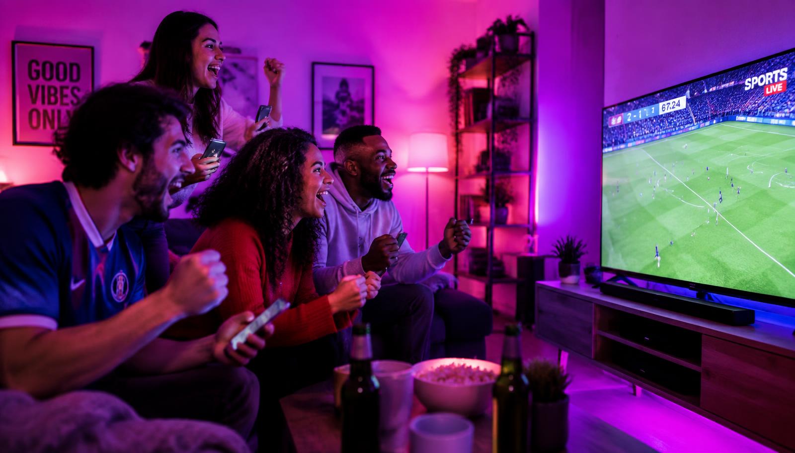 Gruppe schaut gemeinsam einen Live-Casino-Stream auf dem Smartphone